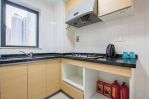 Une cuisine avec une fenêtre, une cuisinière et un évier.