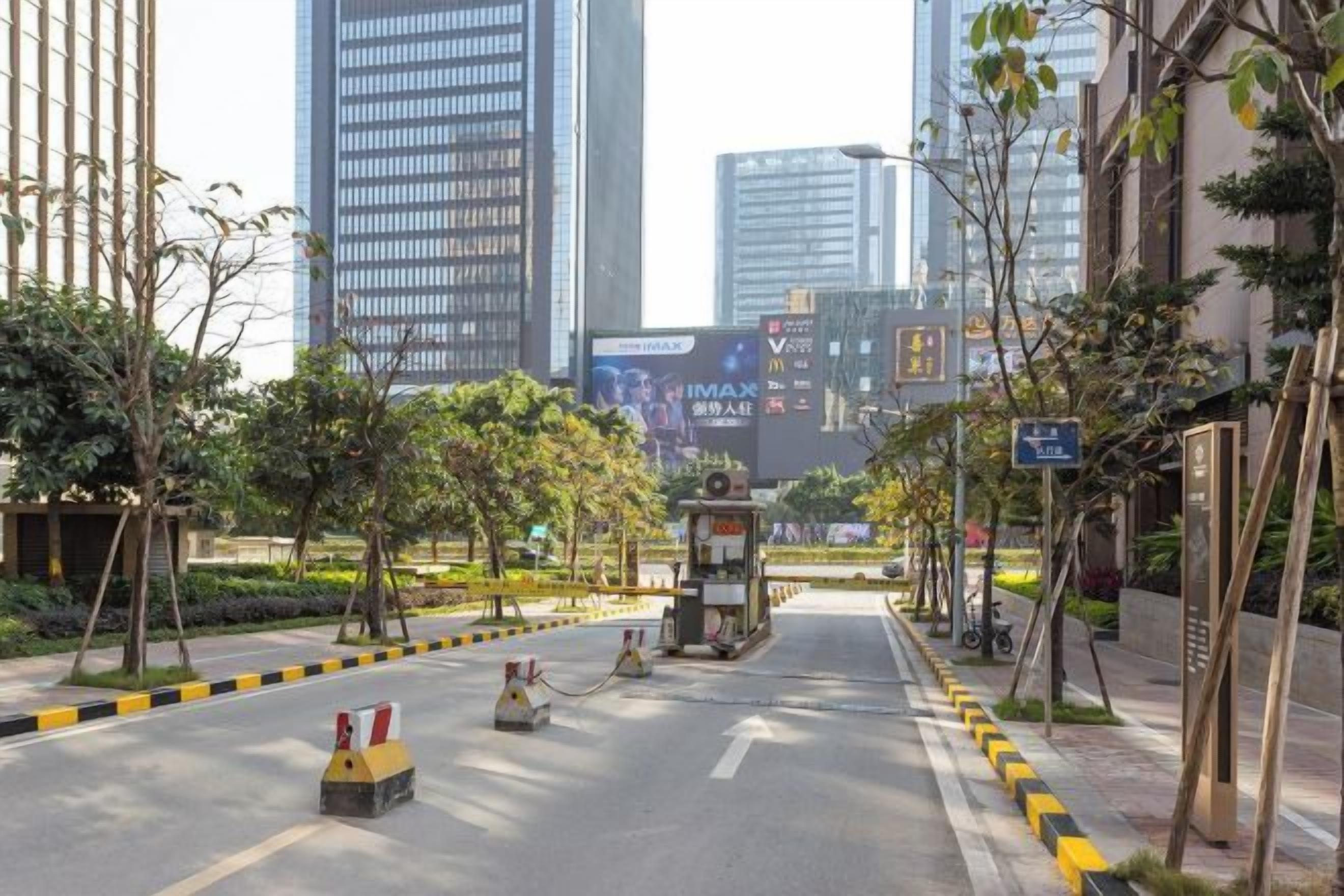 A city street with modern buildings, a clear sky, and a pedestrian crossing.