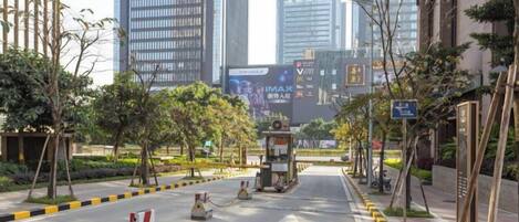 A city street with modern buildings, a clear sky, and a pedestrian crossing.