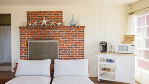 A room with a brick fireplace, two cushioned chairs, a coffee maker, a microwave, and a window with curtains. - Large, Comfortable Room with views of both the Ocean and The Bay! (Trinidad)