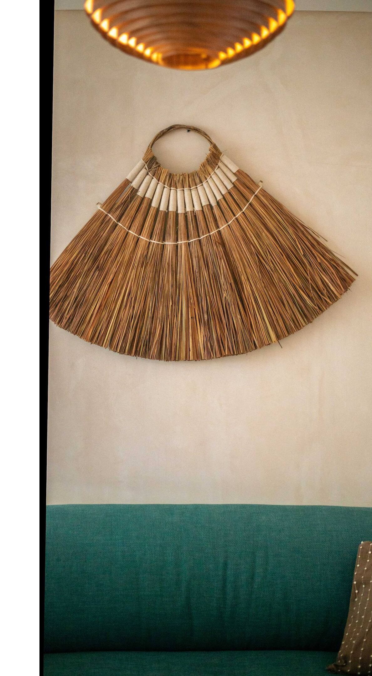Un ventilateur mural au design circulaire, fabriqué à partir de matériaux naturels.