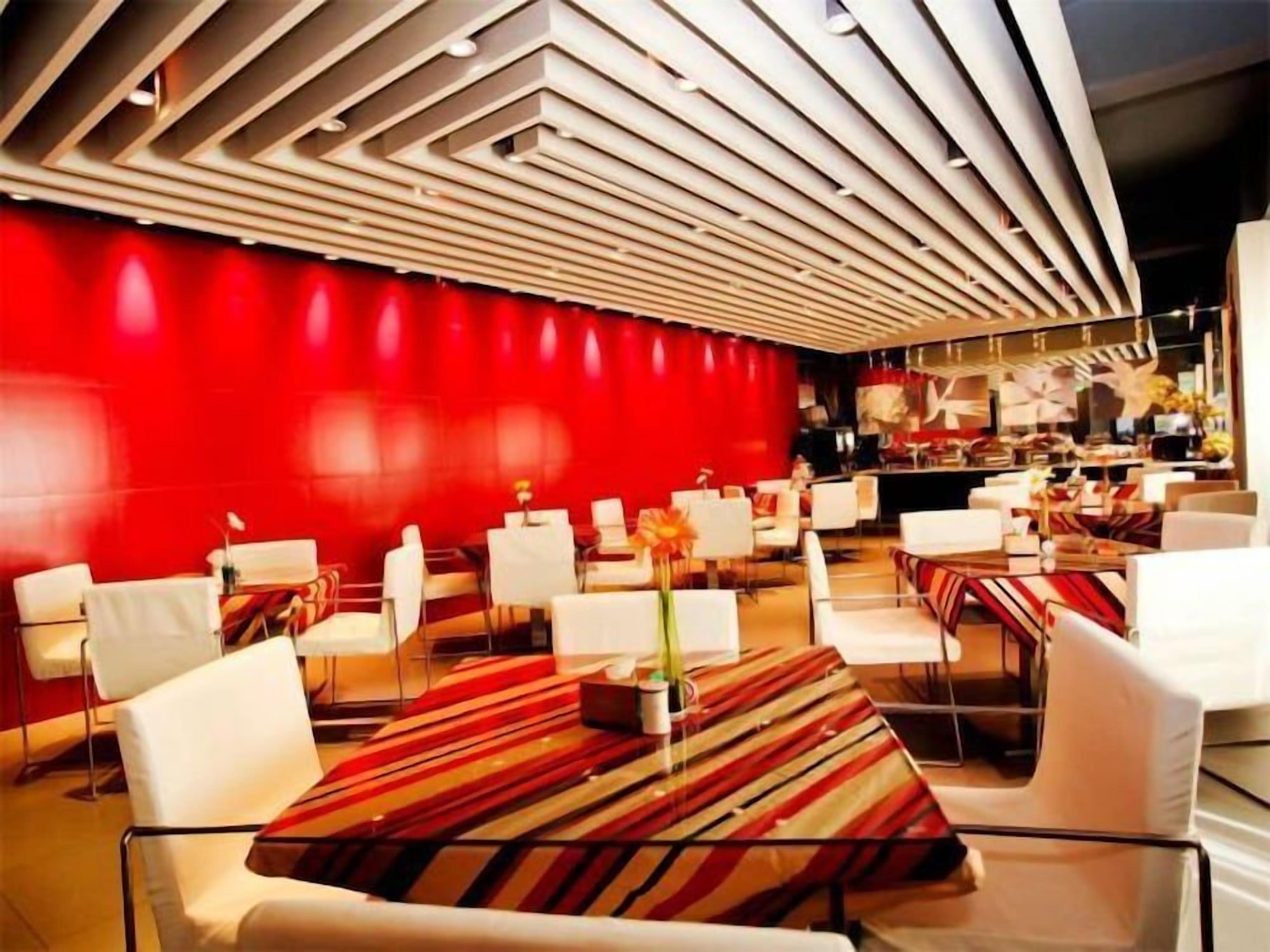 A modern interior with white furniture and a red accent wall.