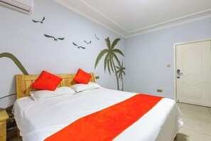 Une chambre d’hôtel avec un lit, une tête de lit en bois et une porte blanche.