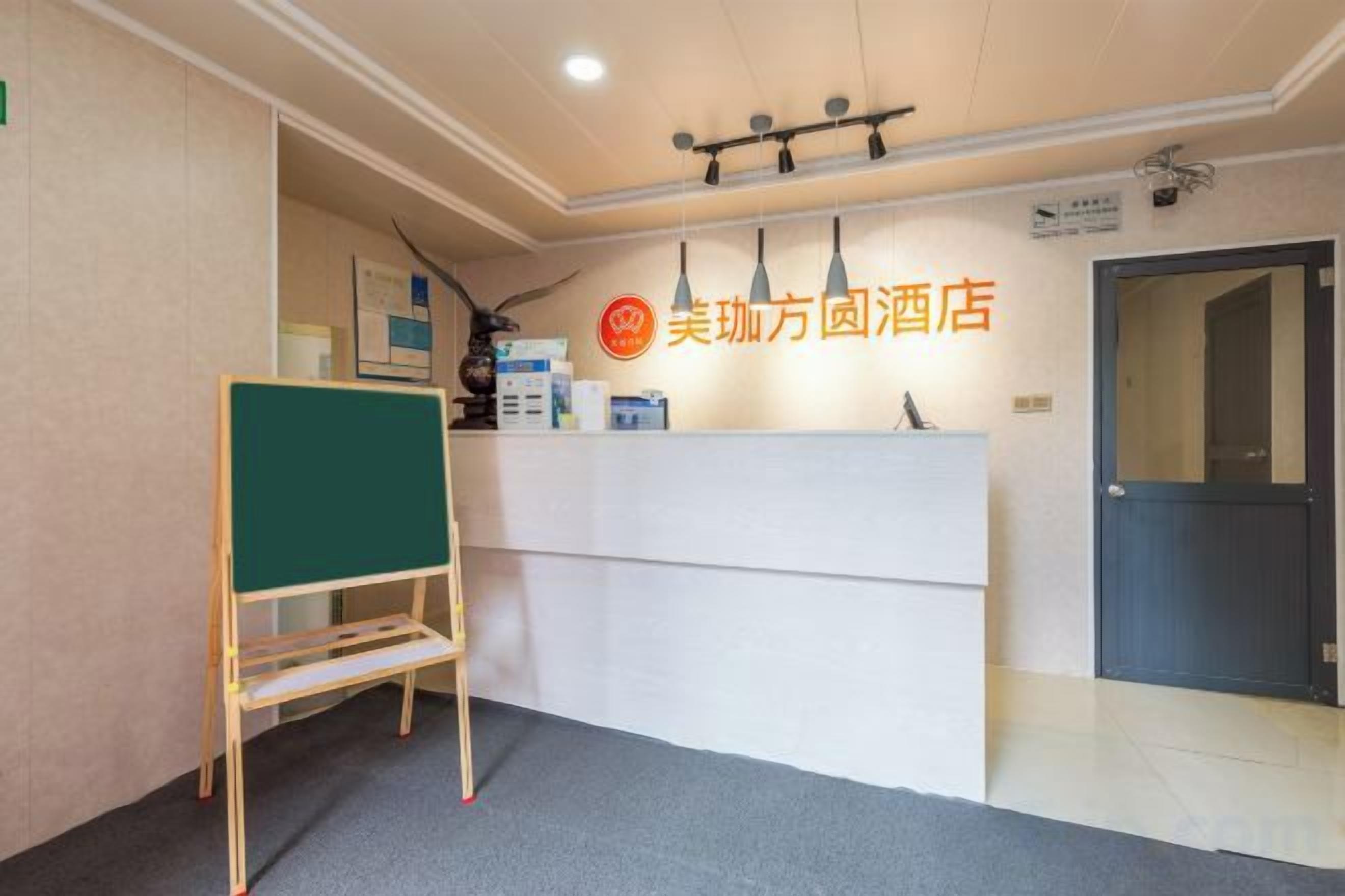 A reception area with a reception desk, a greenboard, and a door.