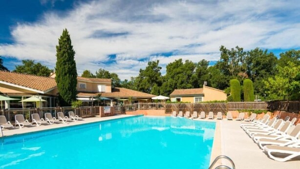 A clear blue swimming pool with lounge chairs and a tall tree in the background. - Mazet Provençal air-conditioned swimming pool parking 5 pers (Gaujac)