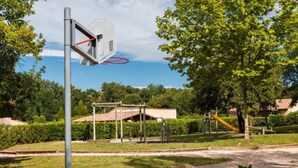 A basketball court with a hoop, surrounded by trees and a playground. - Mazet Provençal air-conditioned swimming pool parking 5 pers (Gaujac)