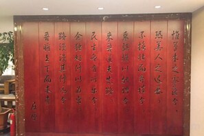 A red wall with vertical text in a foreign language. - Keriya Hotel (Qingdao Golden Beach Branch) (Qingdao)