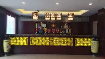 A reception area with a counter, decorative lighting, and traditional Chinese elements.