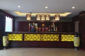 A reception area with a counter, decorative lighting, and traditional Chinese elements. - Keriya Hotel (Qingdao Golden Beach Branch) (Qingdao)