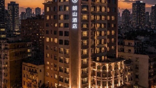 A multi-story hotel with a prominent sign, surrounded by other buildings. - Langshan Hotel (Songshan Lake Vanke Songfo Subway Station Store) (Dongguan)