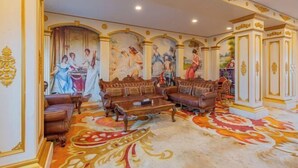 A luxurious room with ornate decor, including a large mural, plush seating, and a patterned carpet. - Jincheng Hotel (Zigui)