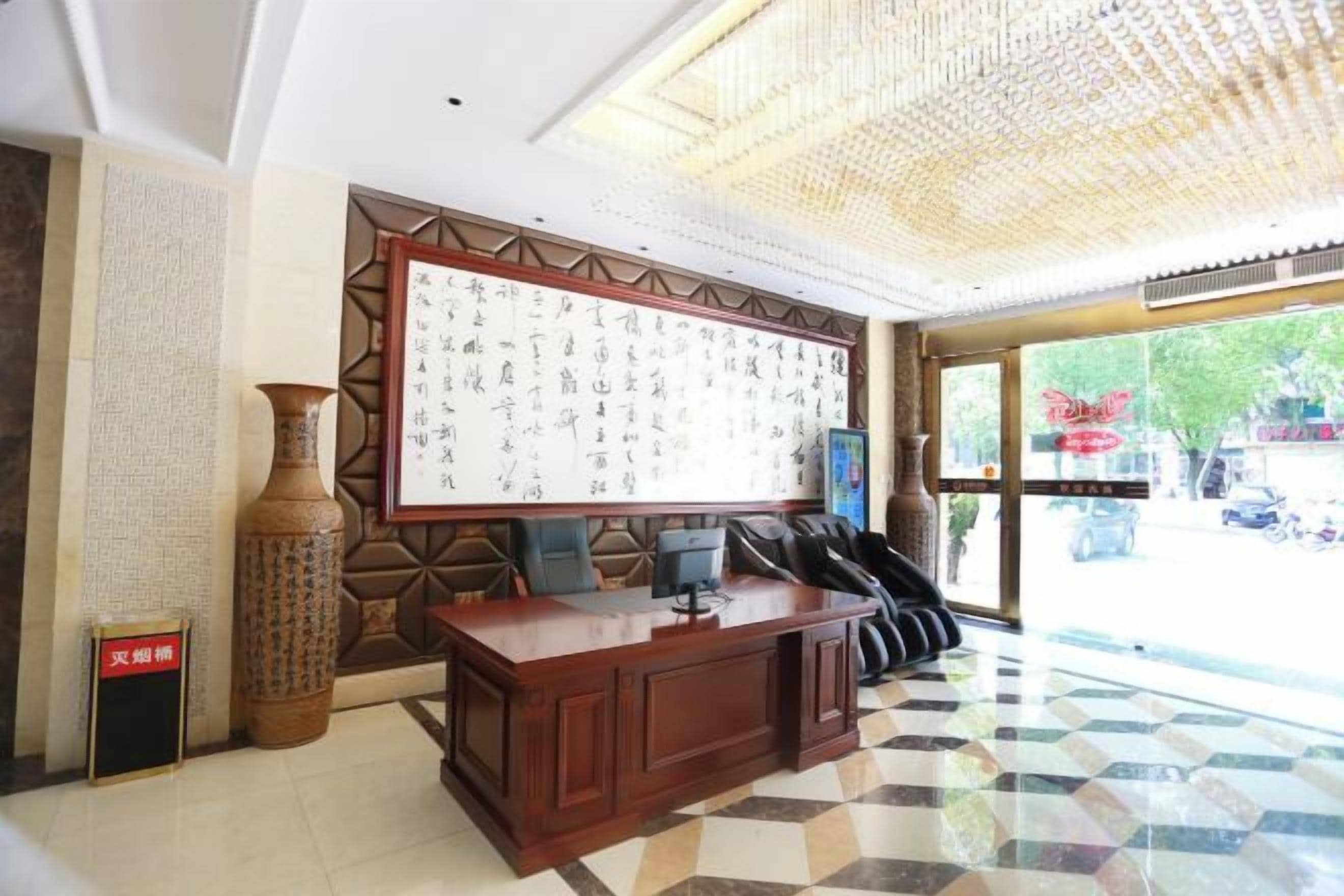 Uma área de recepção com uma grande parede de caligrafia, um balcão de recepção e um posto de check-in.