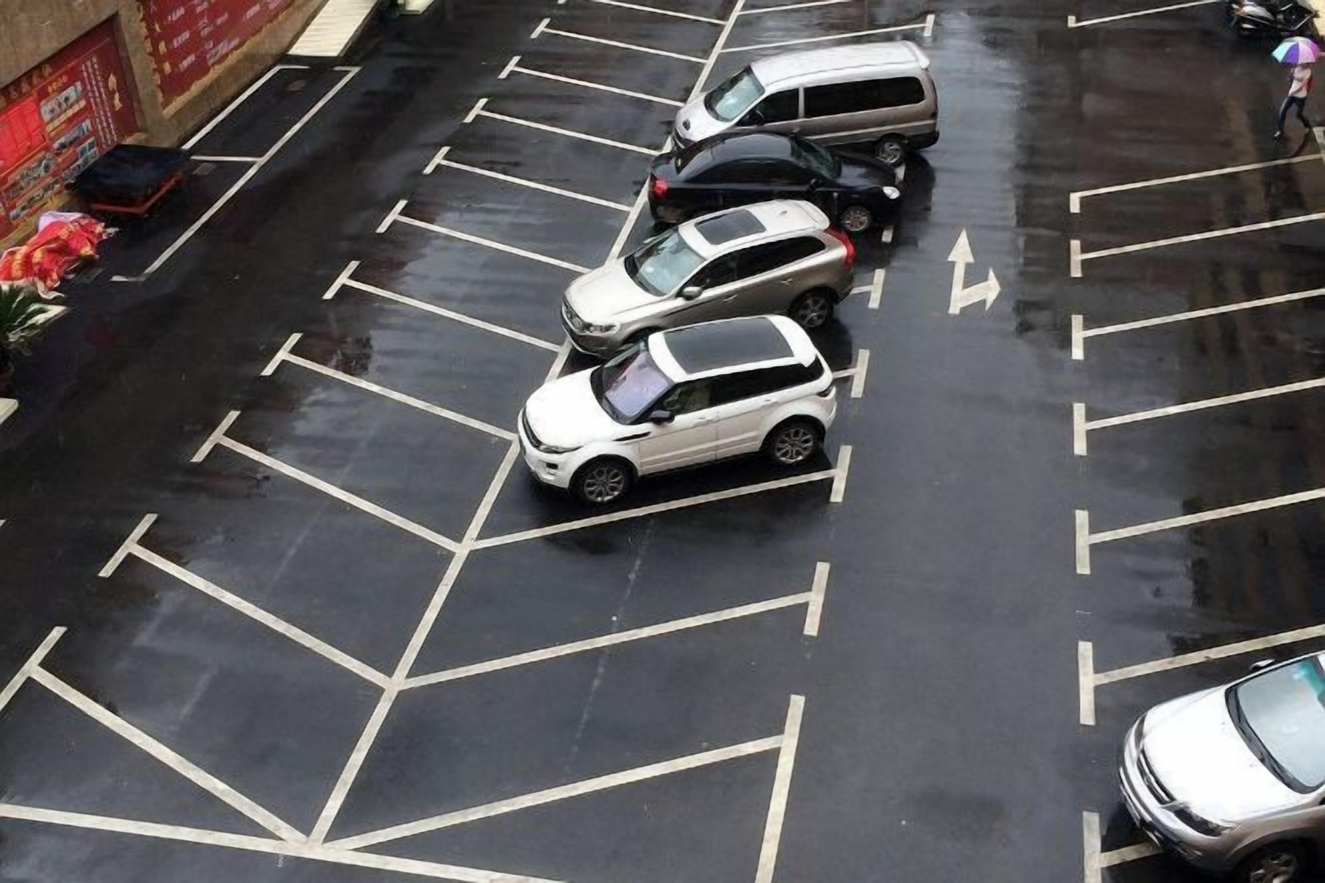 A parking lot with multiple cars parked in designated spaces.