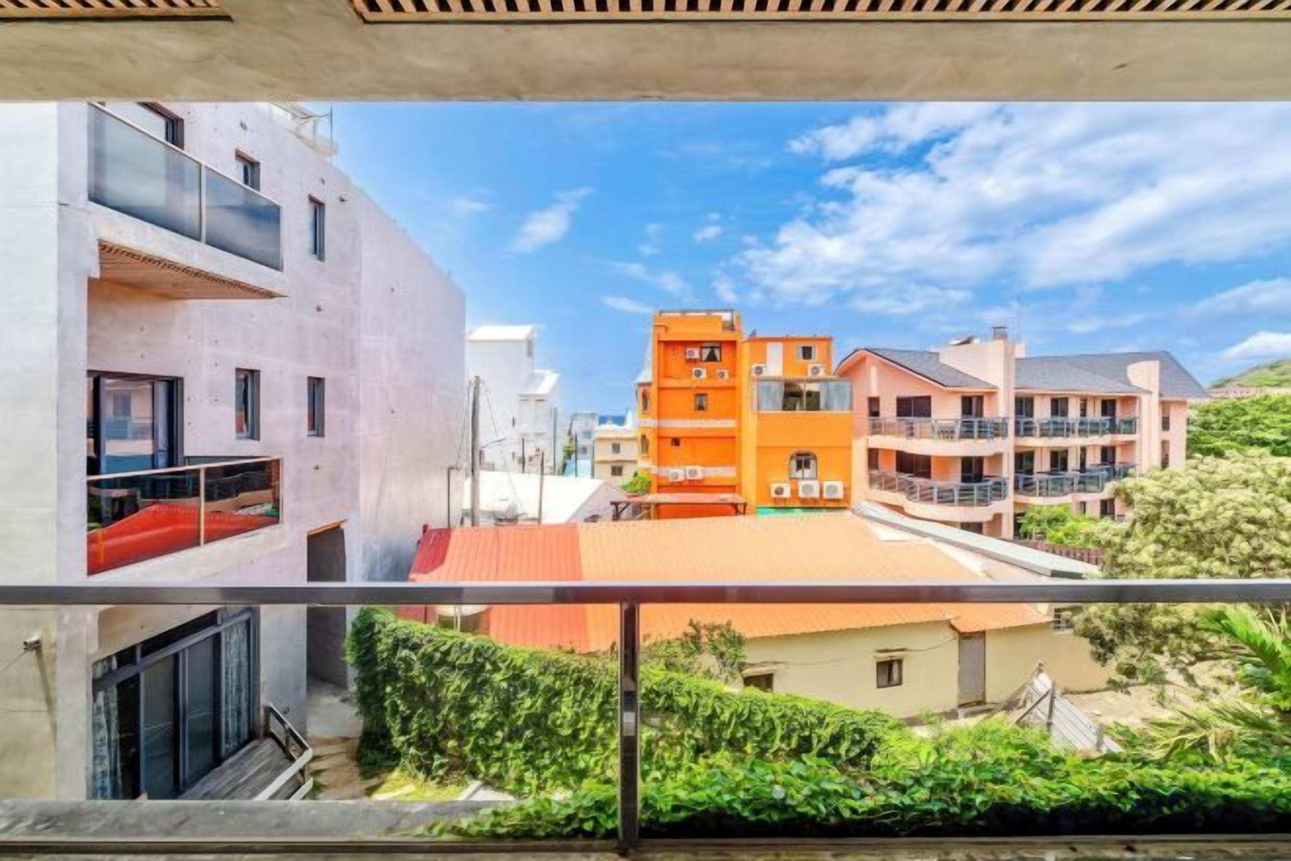 Un quartier résidentiel avec des immeubles à plusieurs étages, des balcons et un ciel dégagé.