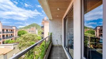 A balcony with a view of surrounding buildings and greenery.