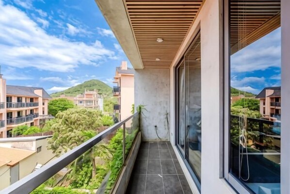 A balcony with a view of surrounding buildings and greenery.
