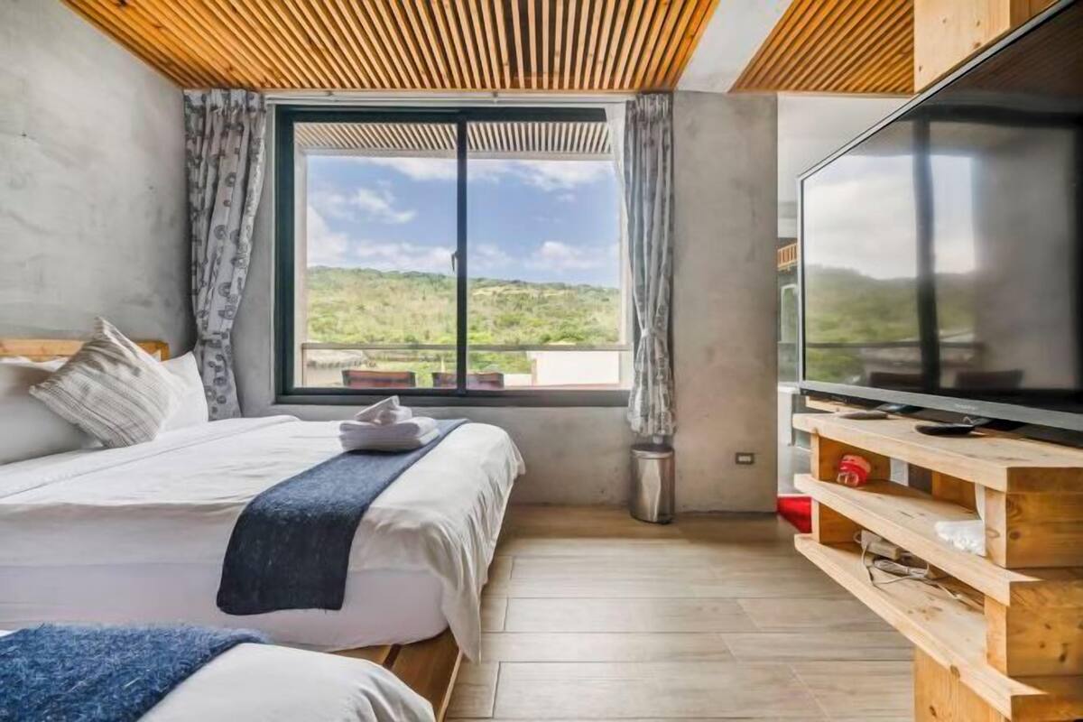 Una camera da letto con un letto, una TV, una finestra vista e un tavolino.
