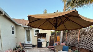 A patio with stone flooring, outdoor furniture, and a pergola with a brown canopy. - The Sweet Spot SB (Santa Barbara)