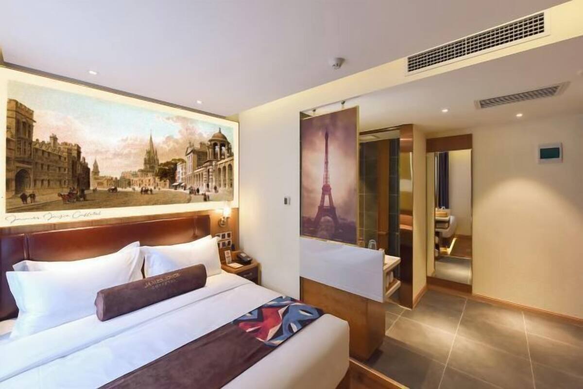 Een hotelkamer met een groot bed, nachtkastje, bureau en een badkamer.