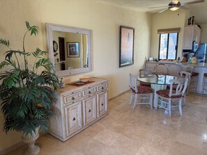 A dining area with a round table, chairs, a large mirror, and a potted plant. - Pacific Ocean & Marina View / Terrasol 341 / Large Balcony / Walk to Marina (Cabo San Lucas)