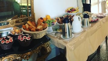 A buffet table with various food items and a coffee station.