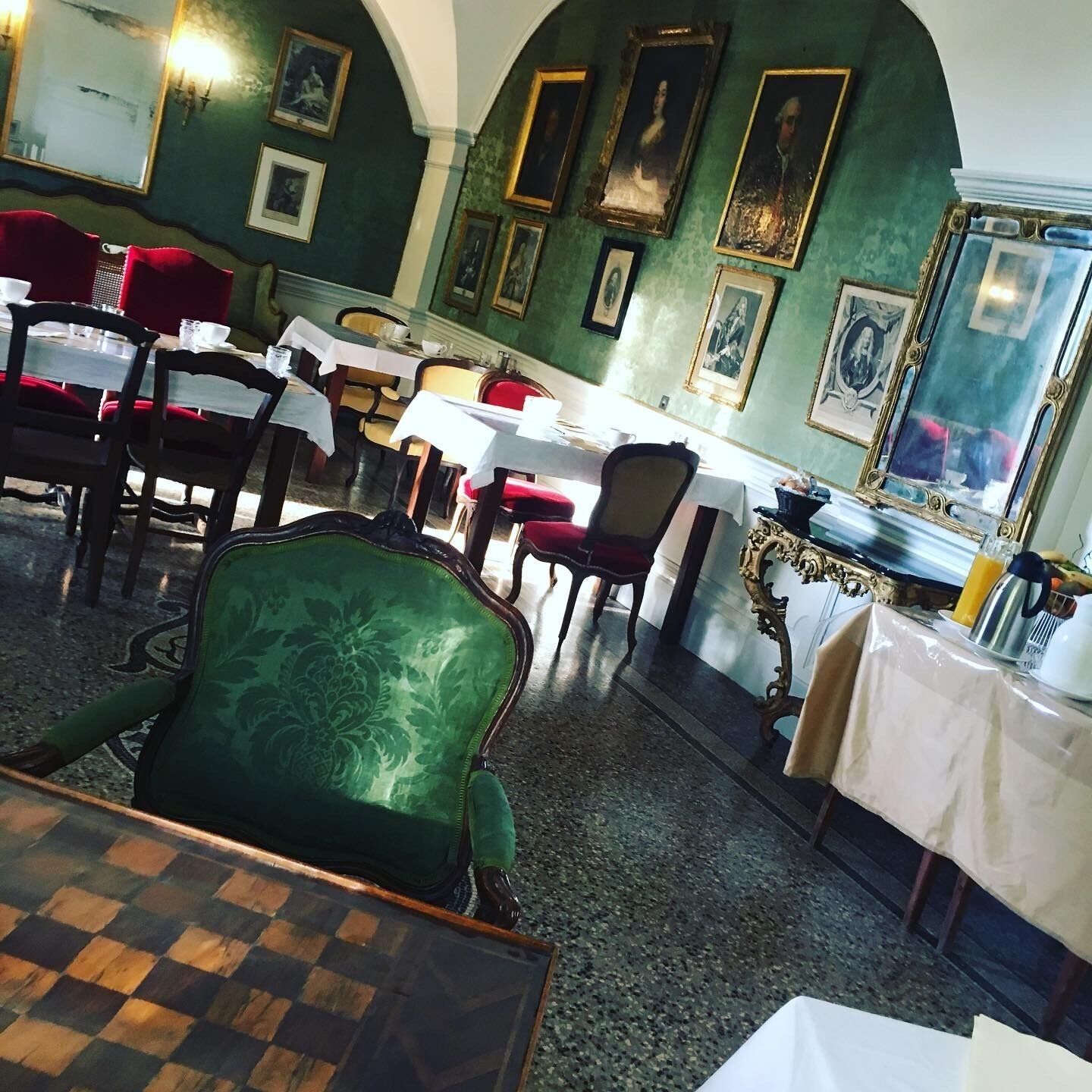Un espace repas avec des tables et des chaises, dont certaines sont recouvertes de nappes blanches.