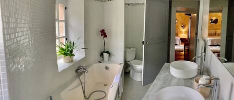 Un baño con bañera, lavabo e inodoro.