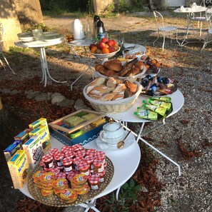 Un montaje para picnic con comida y bebidas sobre una mesa al aire libre.