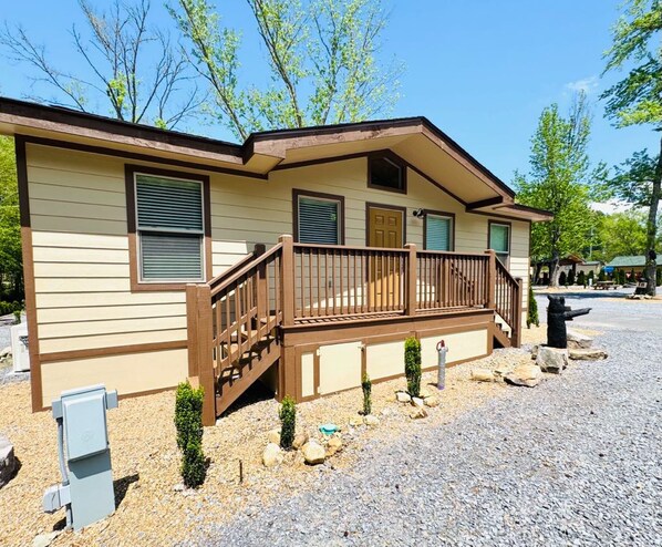 A single-story house with a wooden deck and a small front porch.