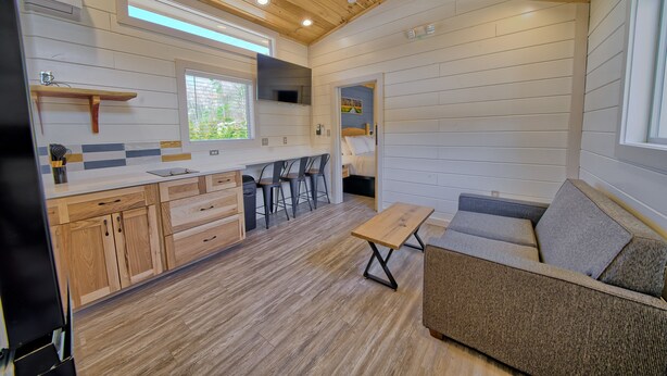 A compact, modern cabin with a kitchen, dining area, and a cozy seating space. - Dudley Creek RV Resort (Gatlinburg)