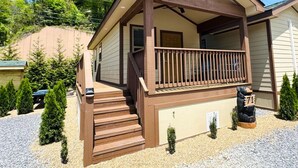 A two-story cabin with a porch, a front door, and a mailbox. - Dudley Creek RV Resort (Gatlinburg)