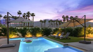 A swimming pool with lounge chairs and umbrellas, surrounded by palm trees and a sunset sky. - The Platinum House!  PGA Signature (Walk to Ernies, Stadium Course!) (La Quinta)