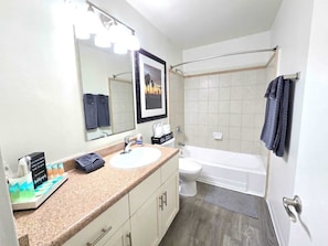 Une salle de bain avec un lavabo, un miroir et une baignoire.