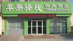 A hotel with a green facade and a sign in Chinese. - Apple Inn Express Hotel (Huantai)