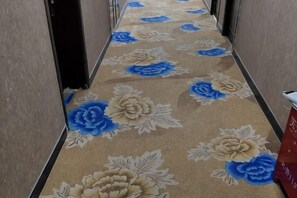 Pasillo alfombrado con motivos florales.