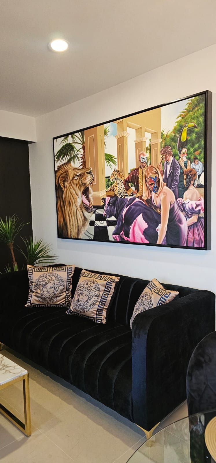 A modern living room with a large painting of a lion and people in a tropical setting.