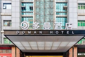 The exterior of the Doman Hotel with its name displayed prominently above the entrance. - Duoman Hotel (Dongguan Xiping Metro Station) (Dongguan)