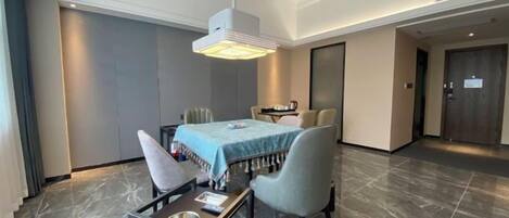 A hotel room with a bed, a desk, and a chair. There is a door and a window.
