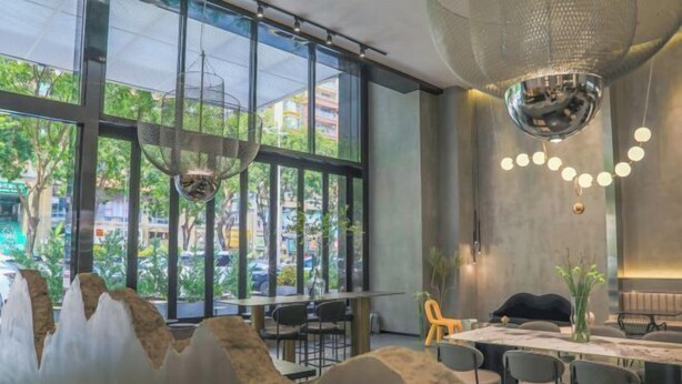 A modern dining area with a large window, a chandelier, and a table with chairs. - Duoman Hotel (Dongguan Xiping Metro Station) (Dongguan)