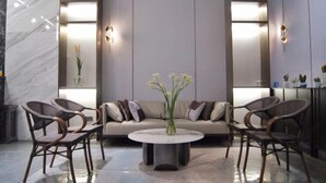 A modern lobby with a round coffee table, two sofas, and four chairs. - Duoman Hotel (Dongguan Xiping Metro Station) (Dongguan)