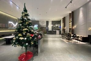 A modern hotel lobby with a Christmas tree, seating area, and a reception desk. - Duoman Hotel (Dongguan Xiping Metro Station) (Dongguan)