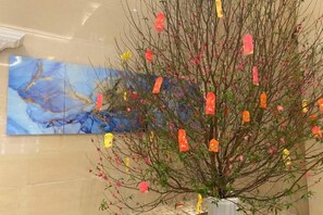 A decorative plant with colorful ornaments in a room with a large abstract painting on the wall. - Duoman Hotel (Dongguan Xiping Metro Station) (Dongguan)