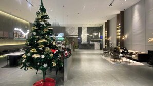 A modern hotel lobby with a Christmas tree, seating area, and a reception desk. - Duoman Hotel (Dongguan Xiping Metro Station) (Dongguan)
