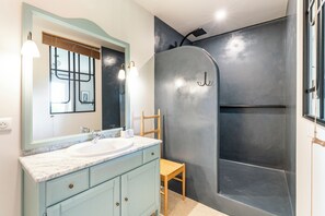A bathroom with a marble sink, a wooden chair, and a shower with a curved wall. - Provencal farmhouse with swimming pool amidst vineyards (Rochegude)