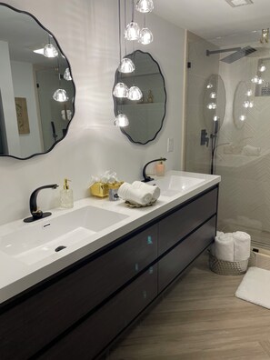 Bathroom features a dual sink vanity with a black faucet and two large mirrors.