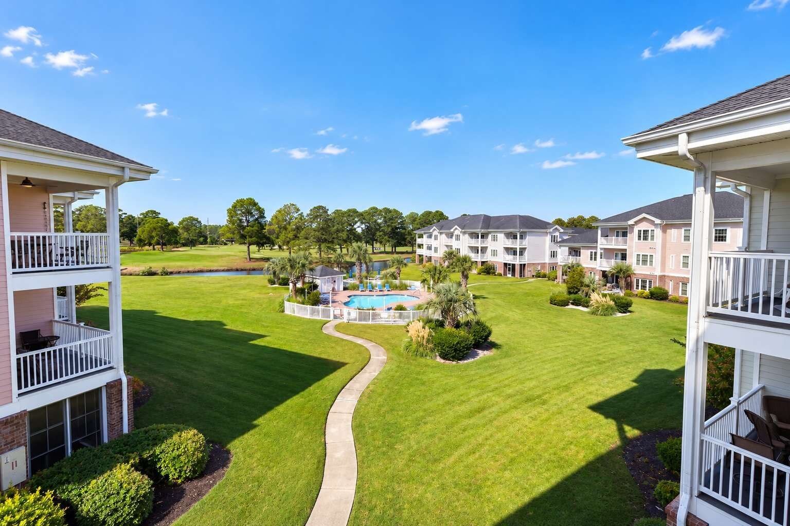 A residential building with a swimming pool, a well-maintained lawn, and a clear sky.
