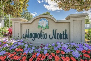A sign for Magnolia North with a flower design above the text.