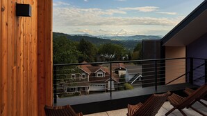 A balcony with wooden railings, a view of a mountain, and a residential area in the background. - One-bedroom suite, Mt Hood views, downtown White Salmon, suite 28 (White Salmon)