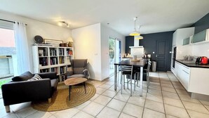 A modern apartment with a living room, dining area, and kitchen.
