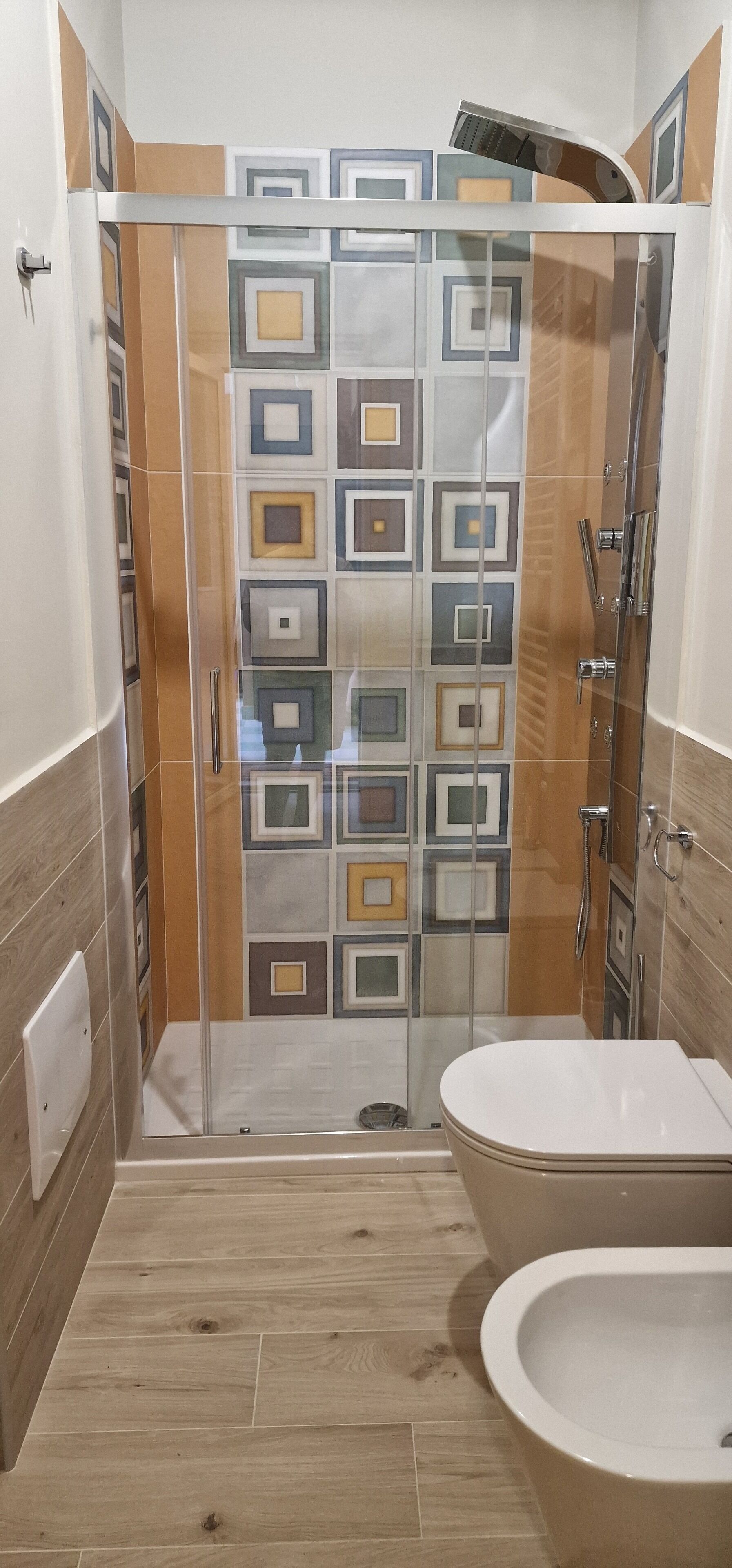 Une douche avec une porte en verre, une baignoire et un espace de douche carrelé.